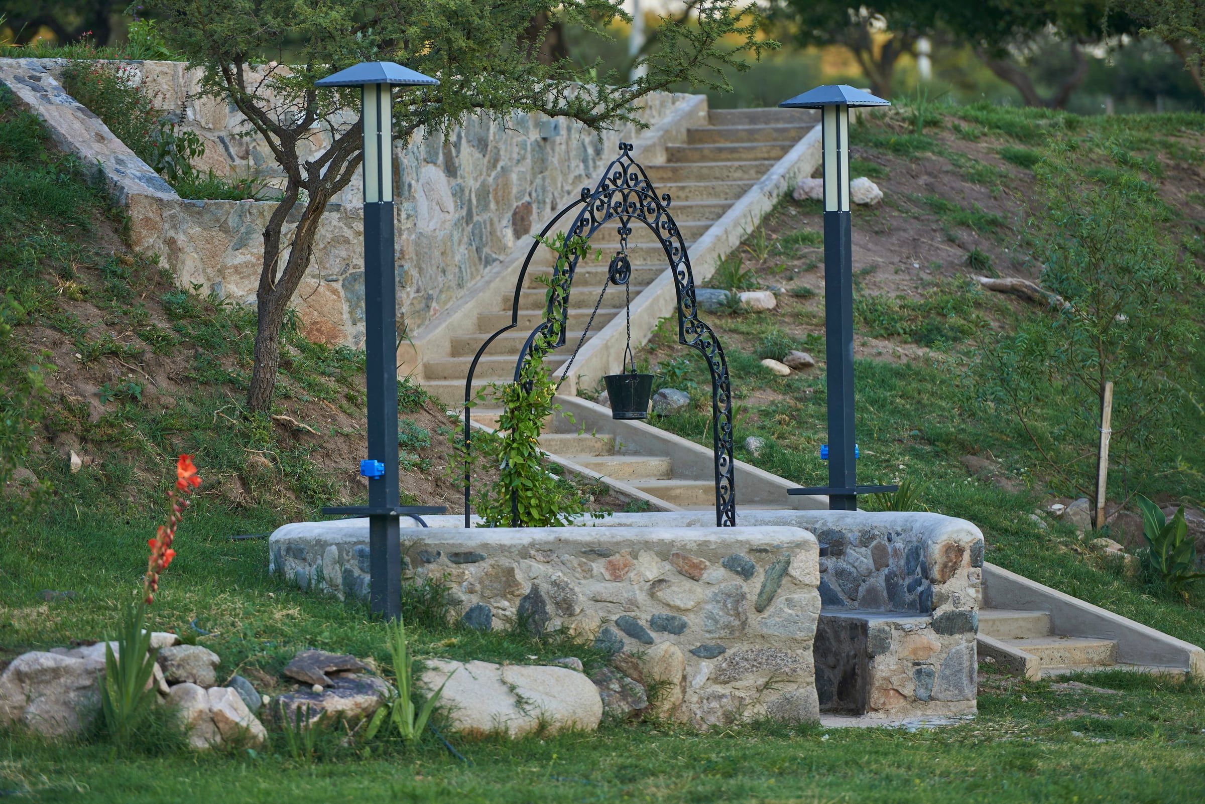 Aljibe de piedra con faroles y escalera
