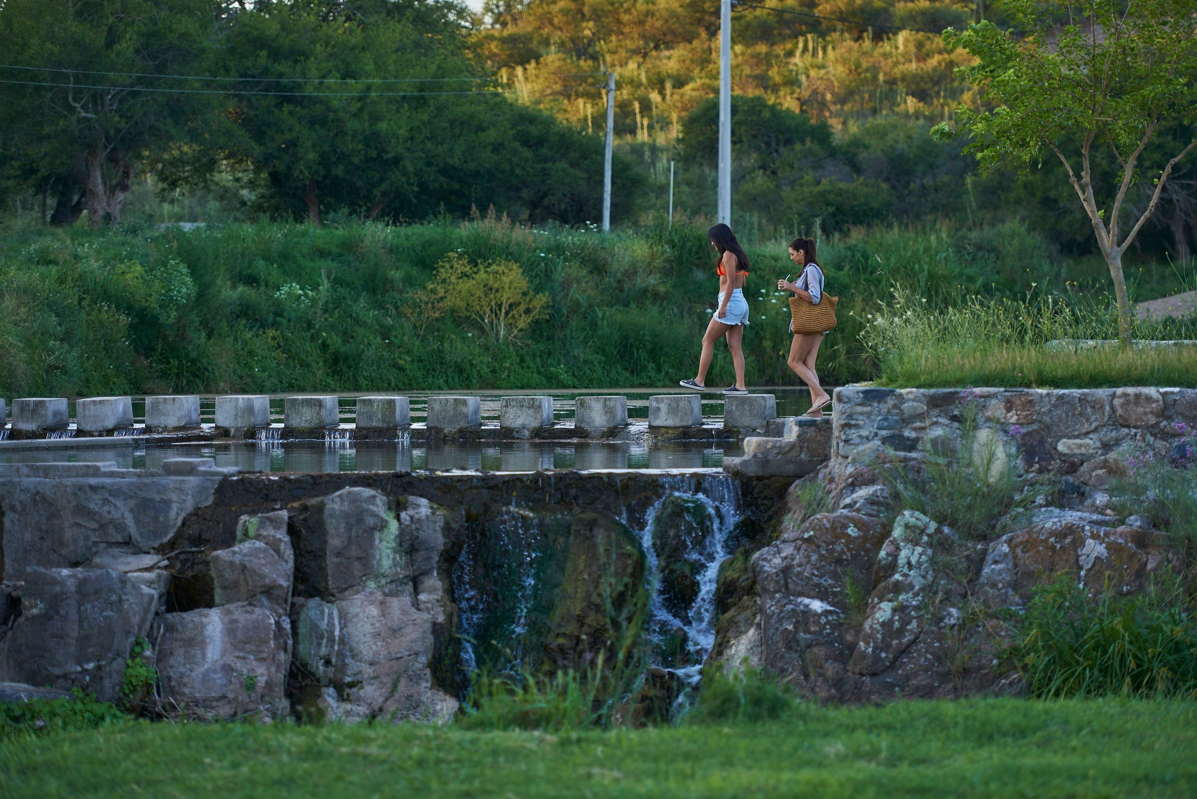 Dos personas caminando sobre el paseo de piedra del dique