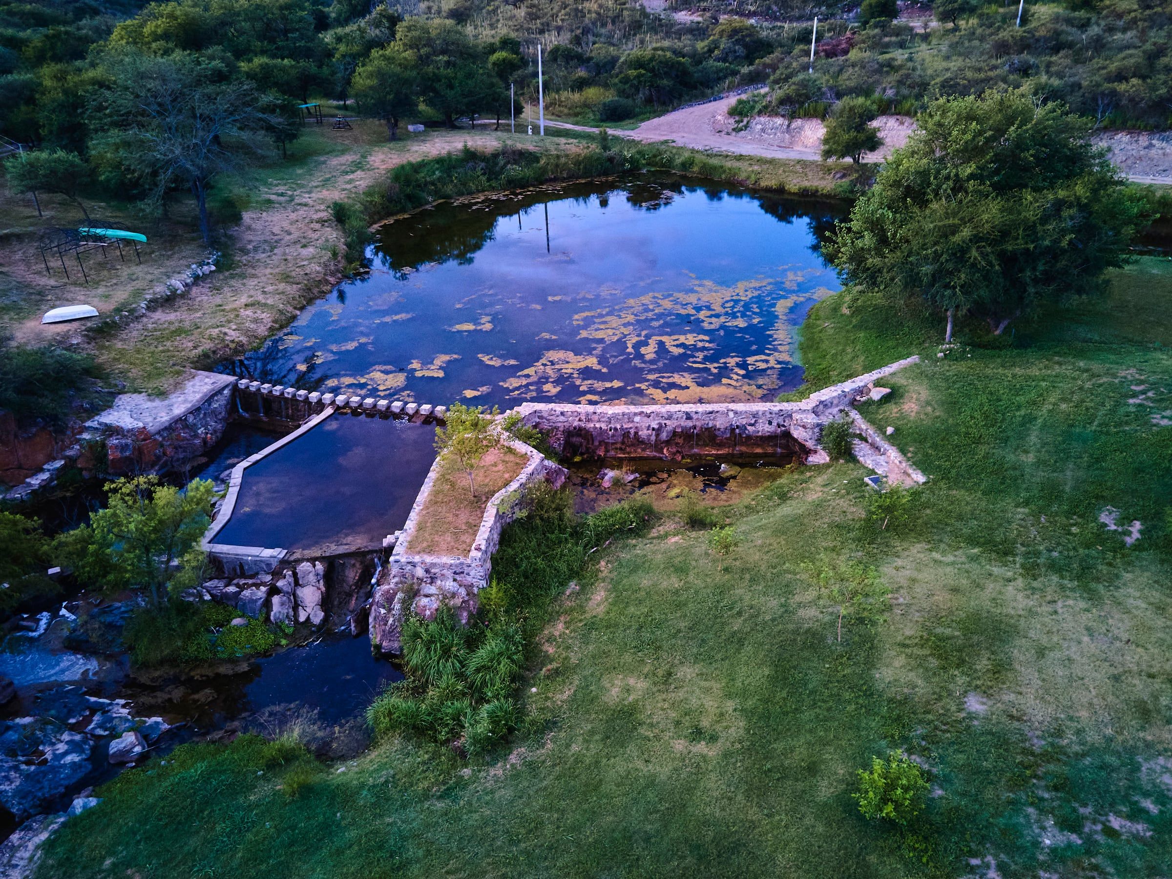 El dique de piedra y el remanso del arroyo, vistos desde el drone